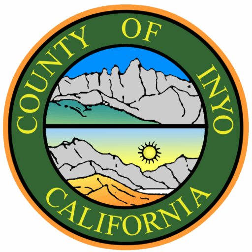Seal of Inyo County, California, with mountains, blue sky, and sun in the center.